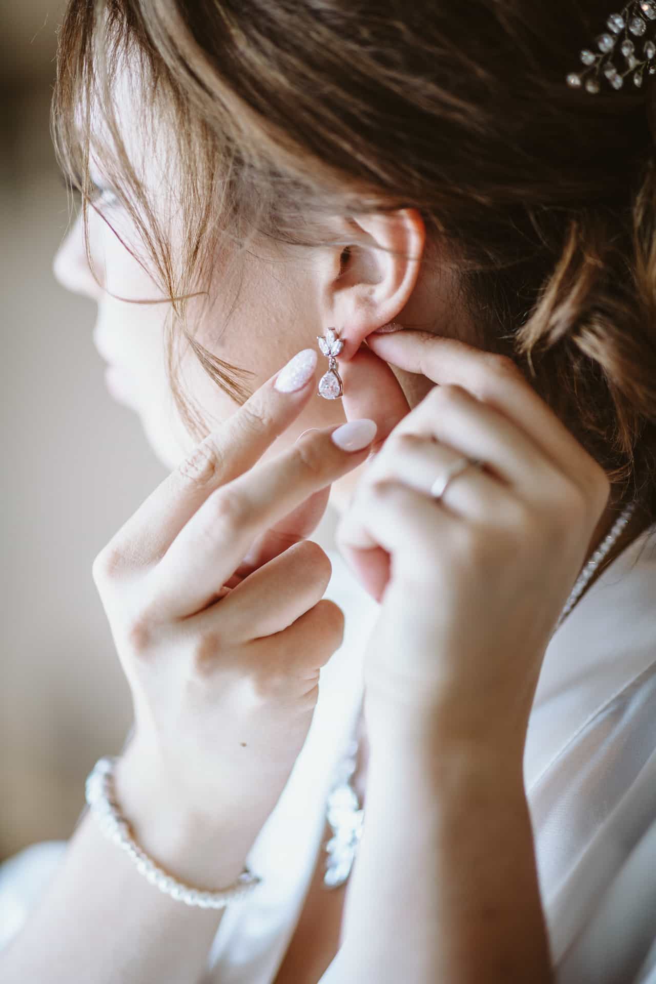 Braut legt vor der Hochzeit einen Ohrring an